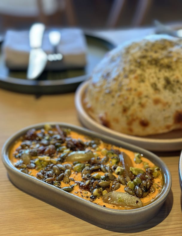 Close up of small plates on a table with bread and dip.