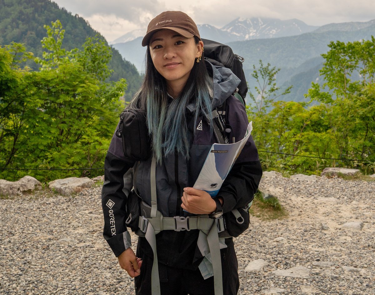A woman with a large backpack hiking in the mountains of Japan