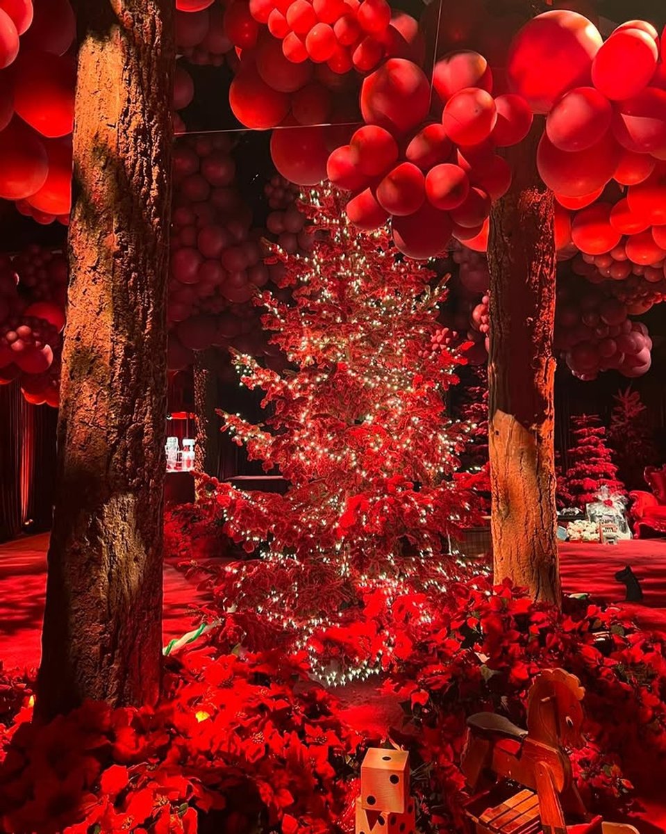 Kourtney Kardashian's Christmas decorations 2024; trees and toys bathed in red light.