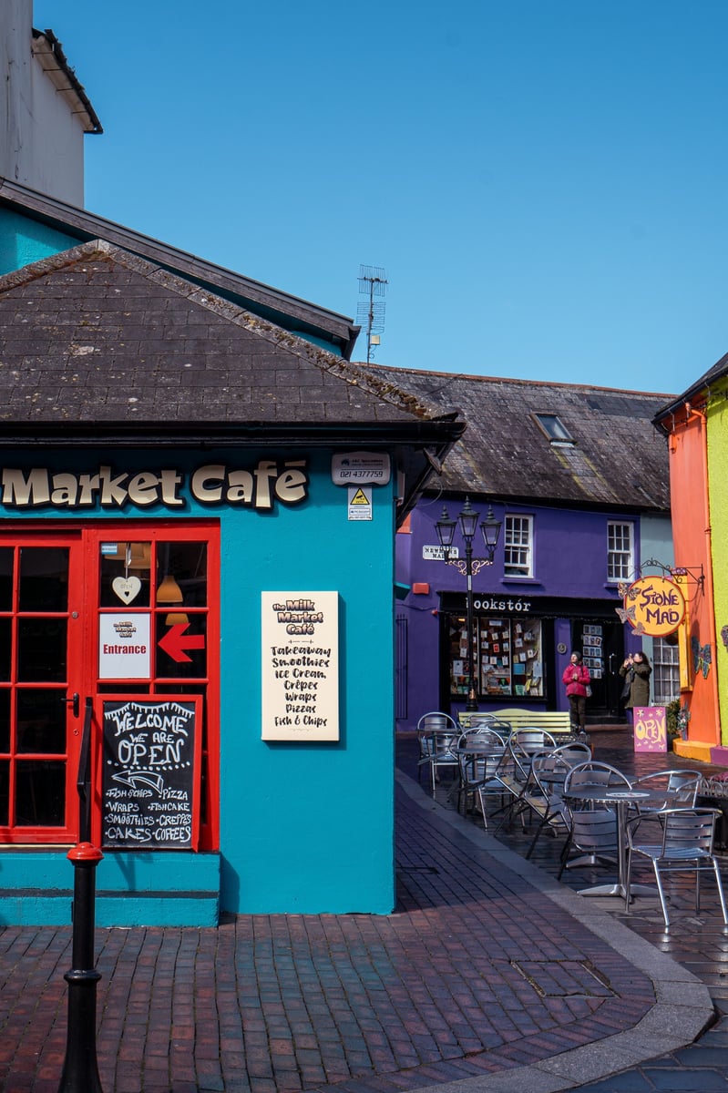 Kinsale, a colourful town near Cork, showing a blue and orange brightly painted market cafe.