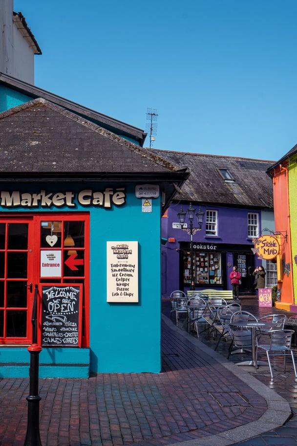 Kinsale, a colourful town near Cork, showing a blue and orange brightly painted market cafe.