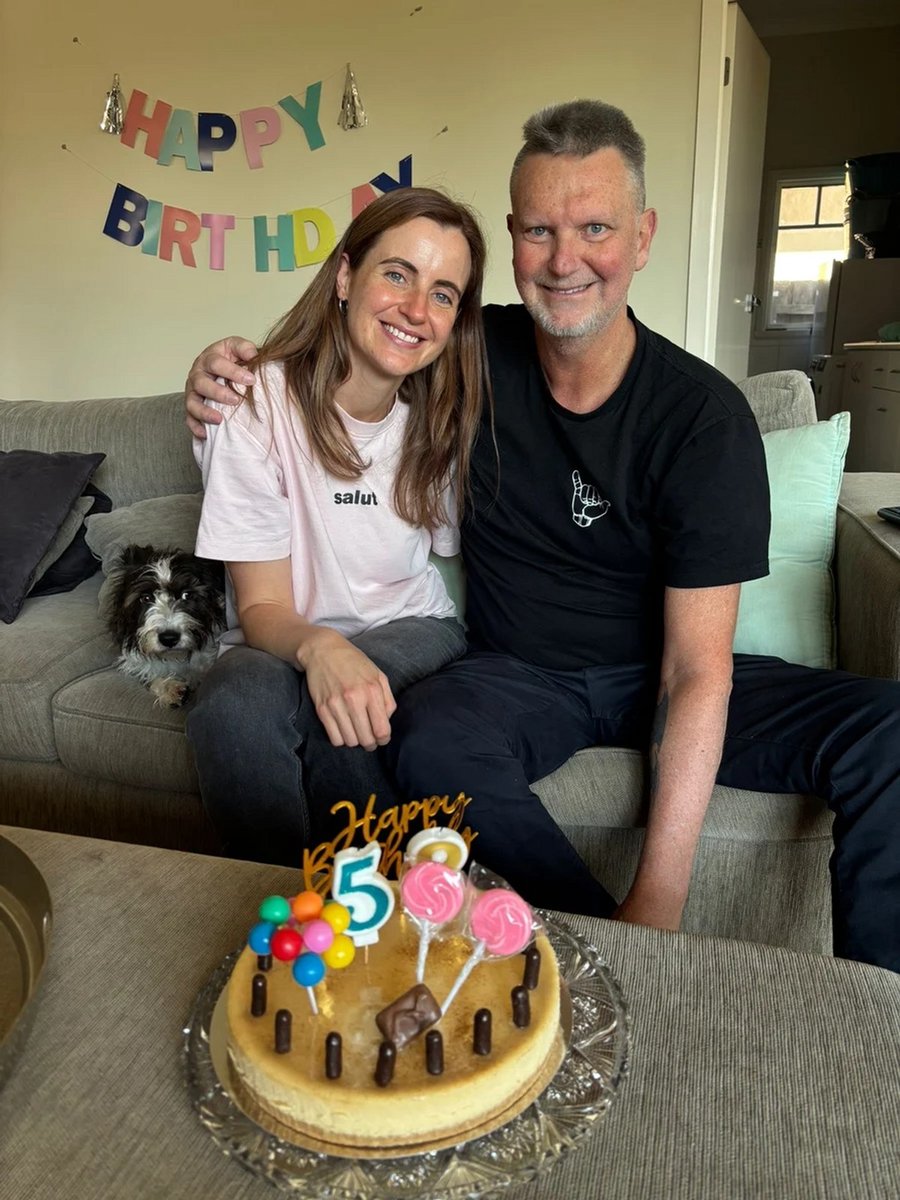 young-woman-and-father-with-birthday-cake-and-dog