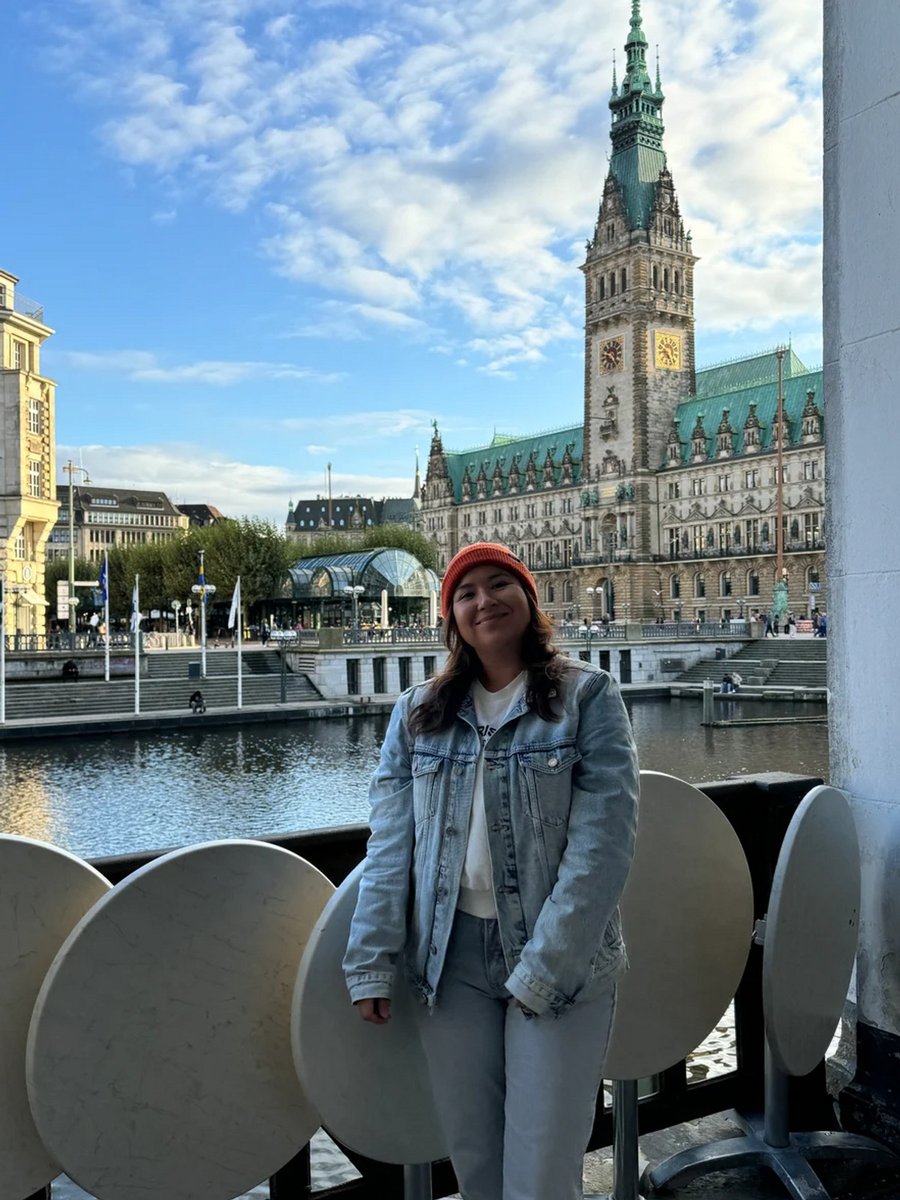 Natasha, the author, smiling in front of a canal in Hamburg.