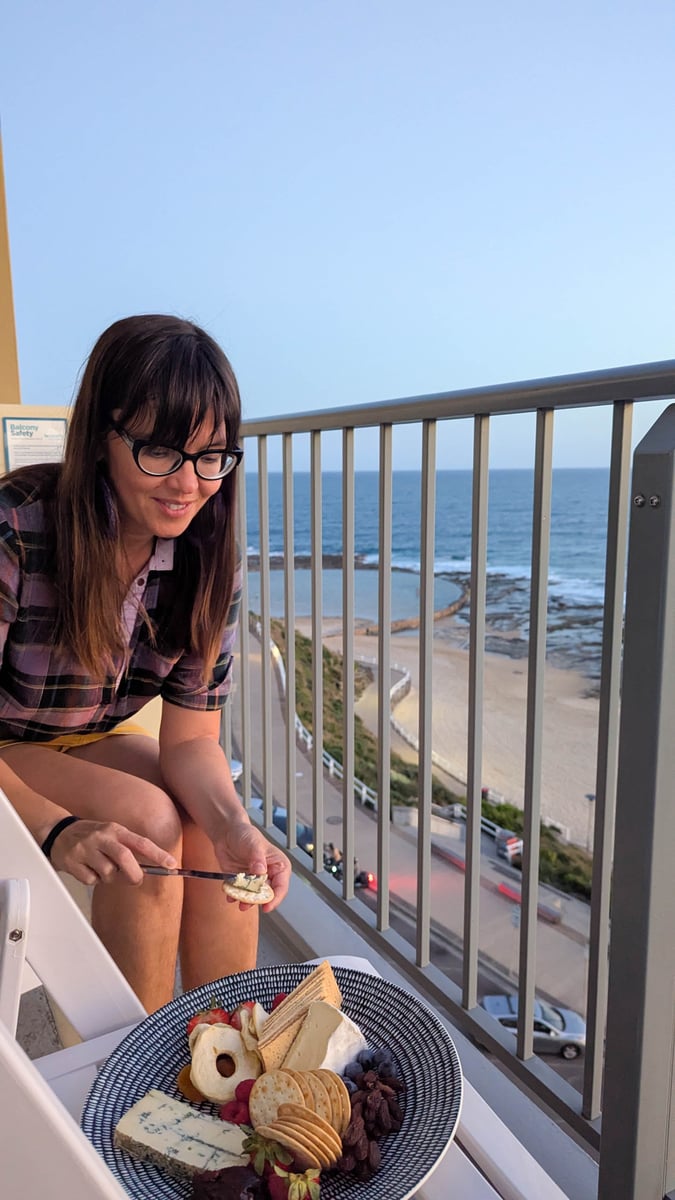 Alexandra eating a cheeseboard on the balcony of Noah's On The Beach in Newcastle.