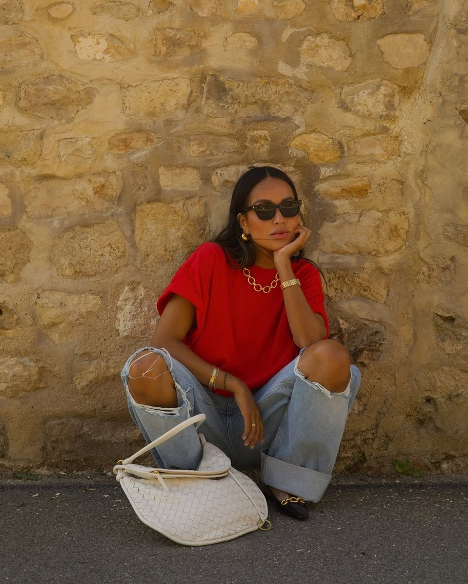 Julie Sarinara wears a cherry red oversized t-shirt and baggy blue jeans.