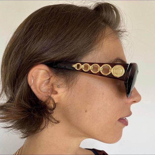 A die profile of a woman wearing sunglasses.