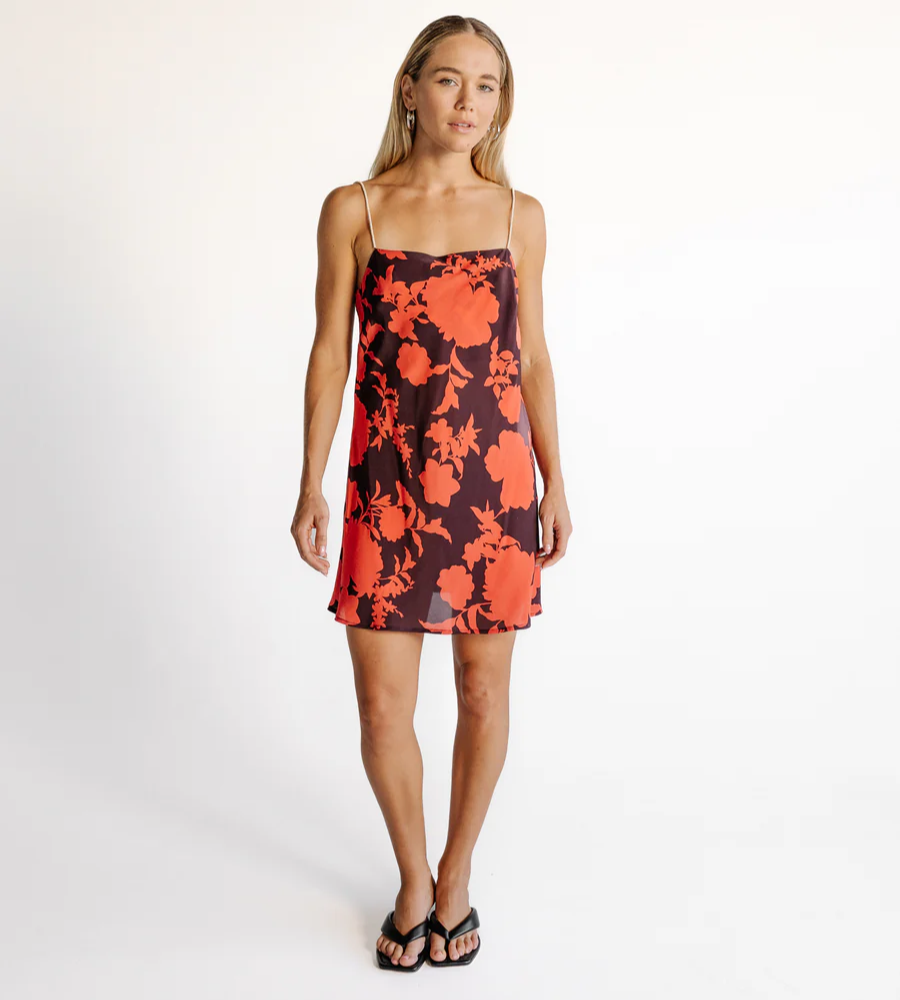 woman wearing a floral mini dress with wooden beaded straps 
