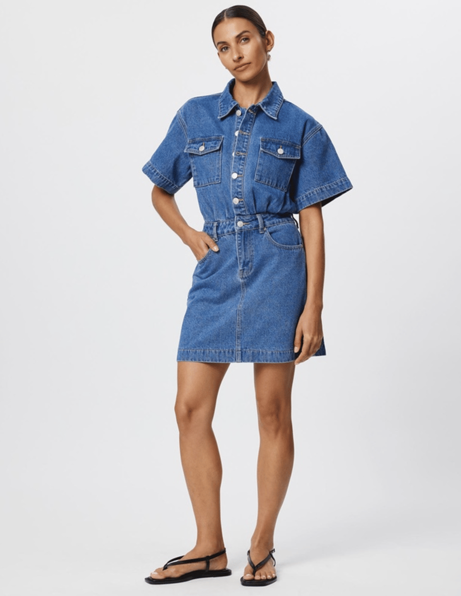 A denim mini dress from Calli, featuring pocked details and buttons to the waist.