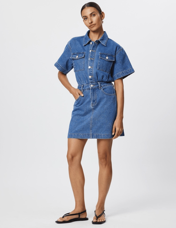 A denim mini dress from Calli, featuring pocked details and buttons to the waist.