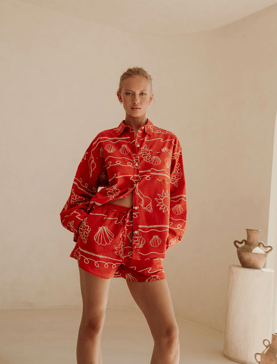 A red seashell-printed long sleeve shirt and matching shorts.