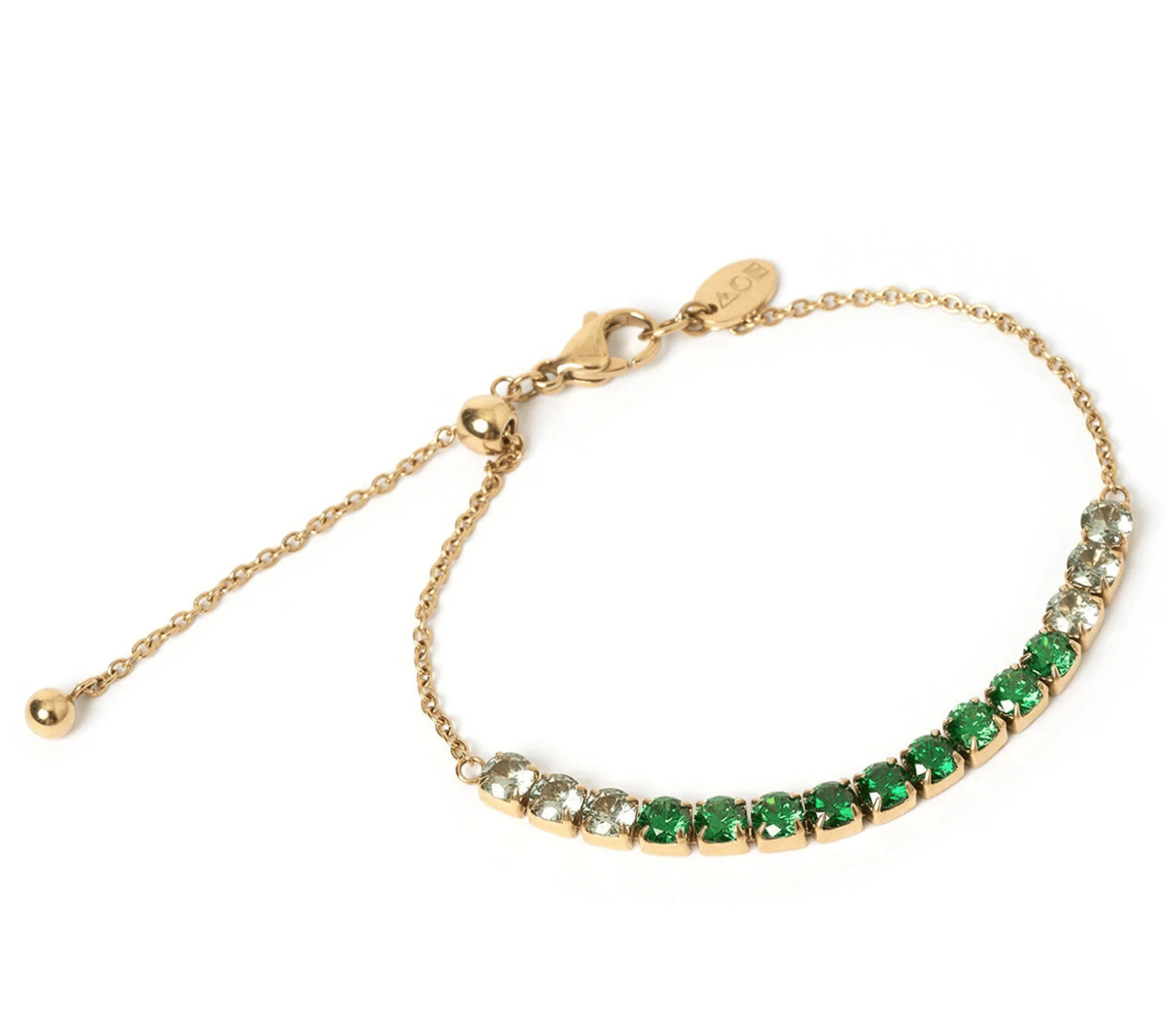 An emerald tone tennis bracelet.