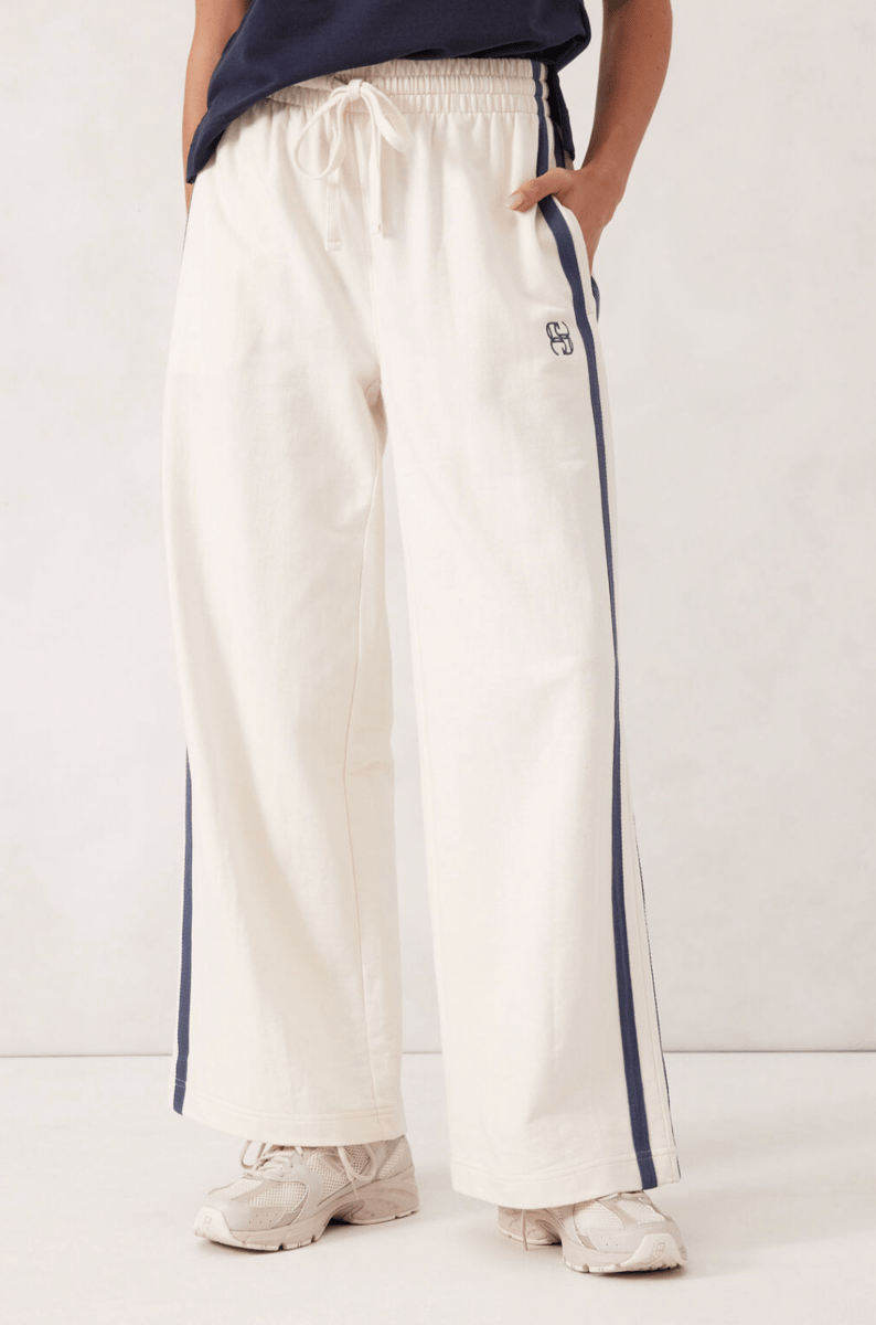 White terry trackpants with a navy side stripe.