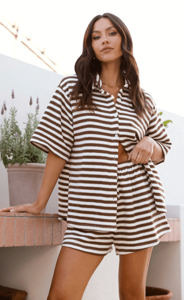 Model wears a striped short and shirt set in brown and white.
