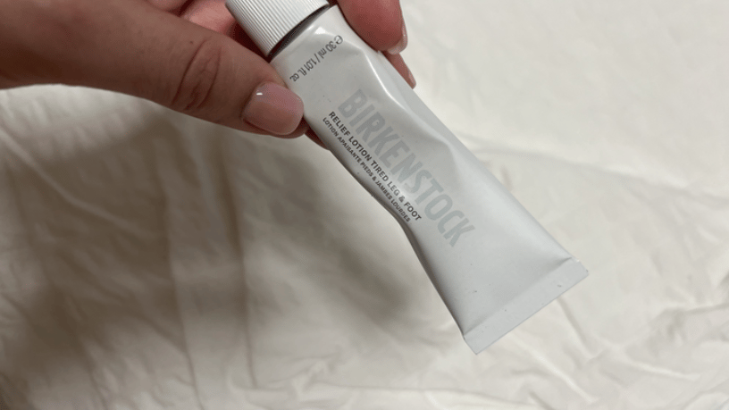 Birkenstock Nourishing Foot Balm pictured in a hand, over a white background.