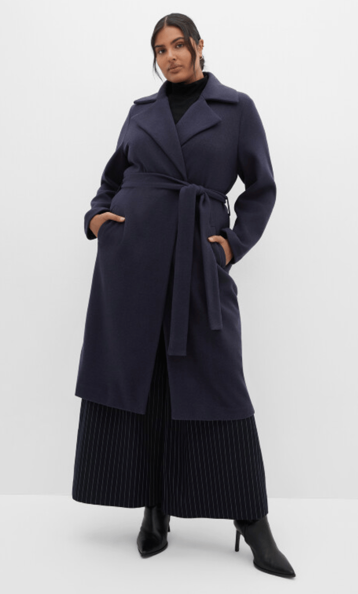 woman wearing belted coat in navy from city chic