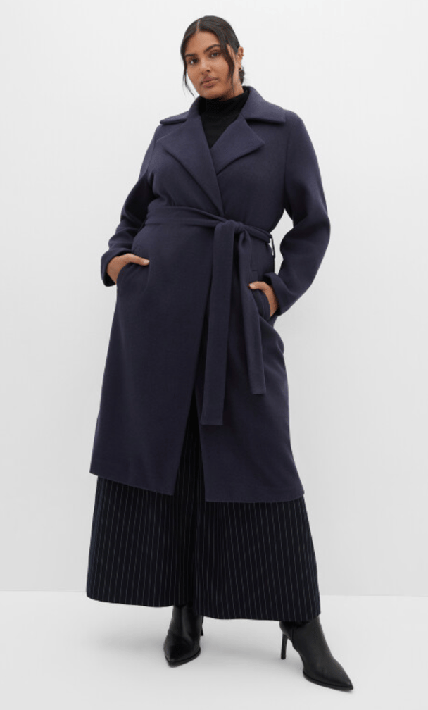 woman wearing belted coat in navy from city chic