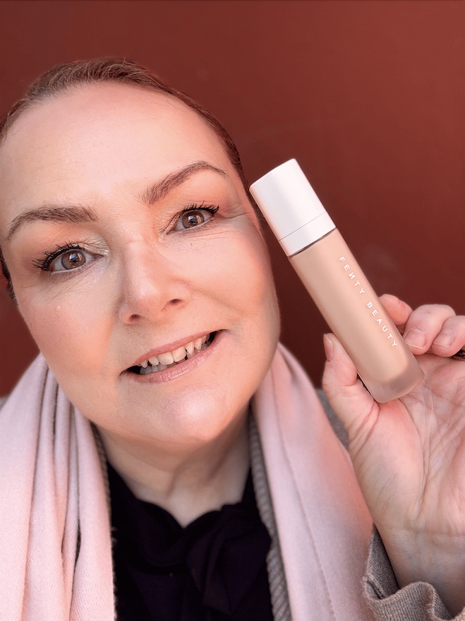 woman holding fenty beauty foundation