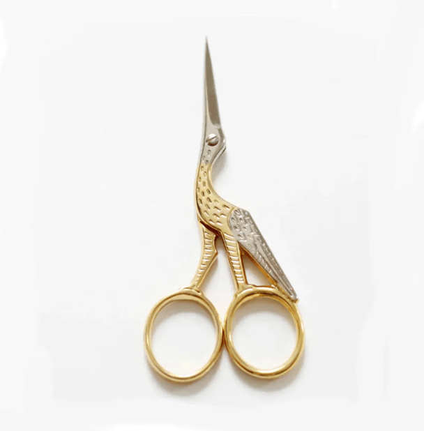 A gold and silver pair of scissors designed in the shape of a bird.