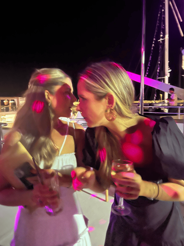 Two women talking to each other at a party.
