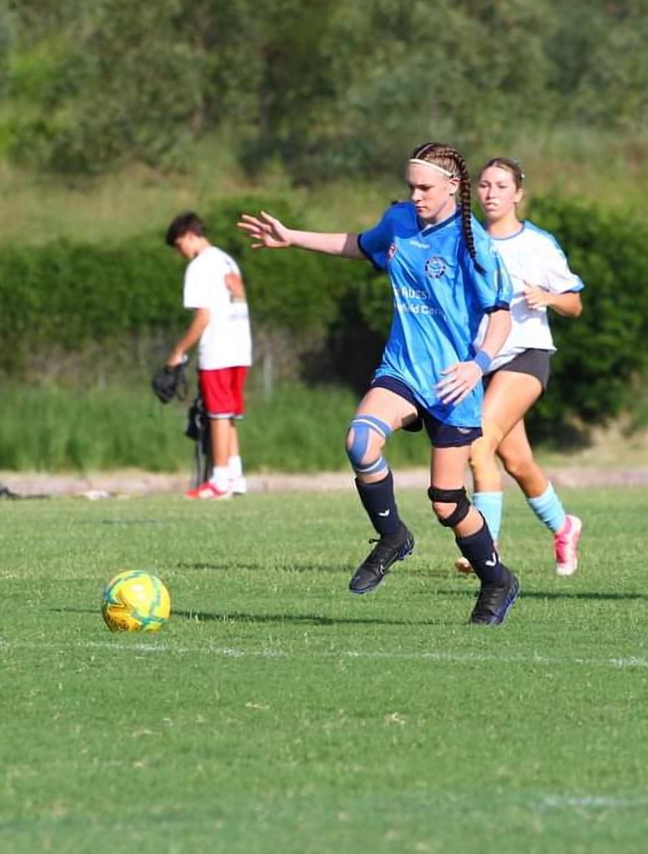 Young girl playing soccer on a field