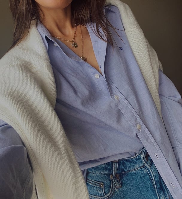 A selfie with shirt and jumper over shoulders.