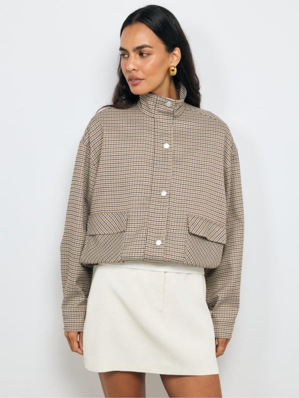 Model wearing light gingham jacket buttoned up.