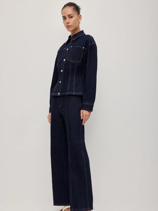 Woman wearing a matching dark indigo wash denim set.