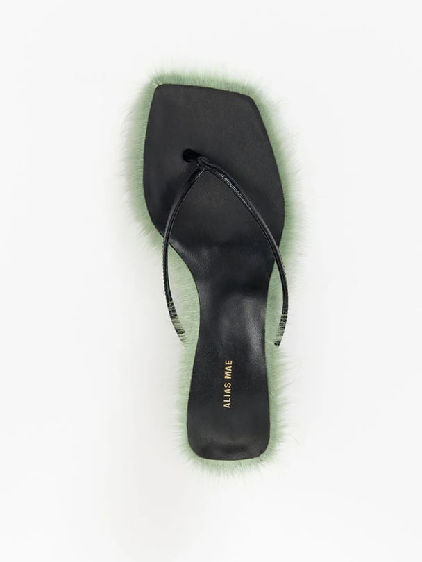 Black thong kitten heels with green hair trim.