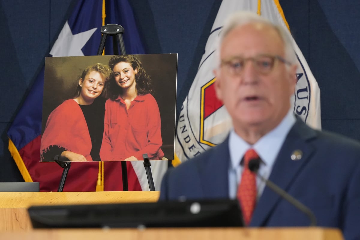 With a photo of sisters Jennifer and Sarah Harbison in the background, Mayor Kirk Watson speaks at a news conference.