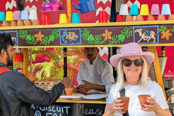 Jo holding beverages in unglazed, biodegradable clay cups.