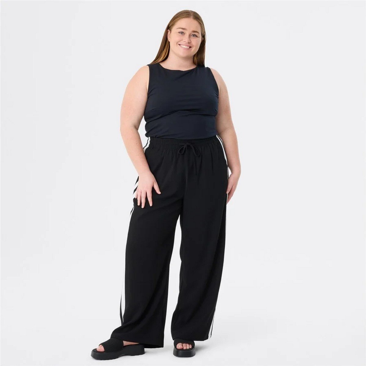 woman wearing black tracksuit pants from Big W 