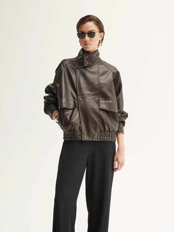 woman wearing elka collective brown bomber leather jacket.