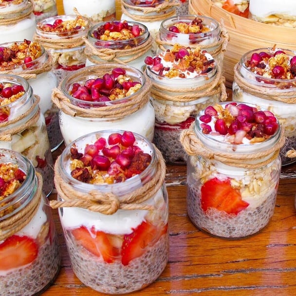 Chia seed pudding jars topped with strawberries, yoghurt and garnish.