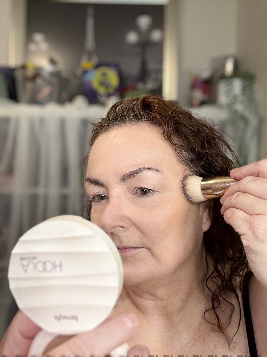 Close-up of Hoola Wave Balm being stamped onto mature skin for a natural, buildable bronze.