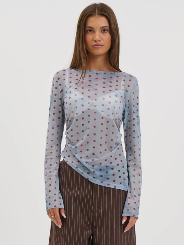 Blue sheer long sleeve top with red polka dots. 
