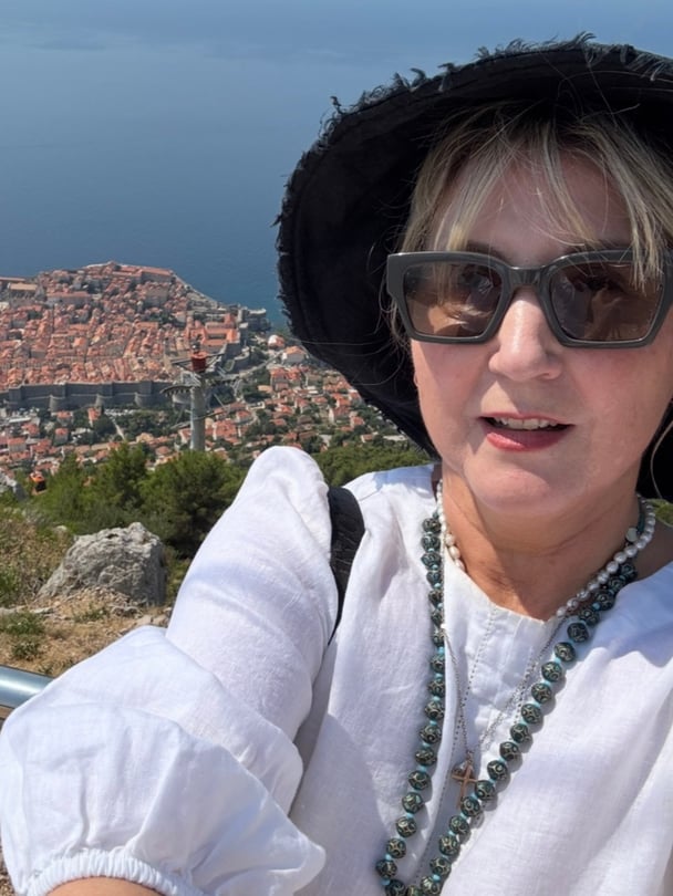 Catherine smiling selfie overlooking a European view.