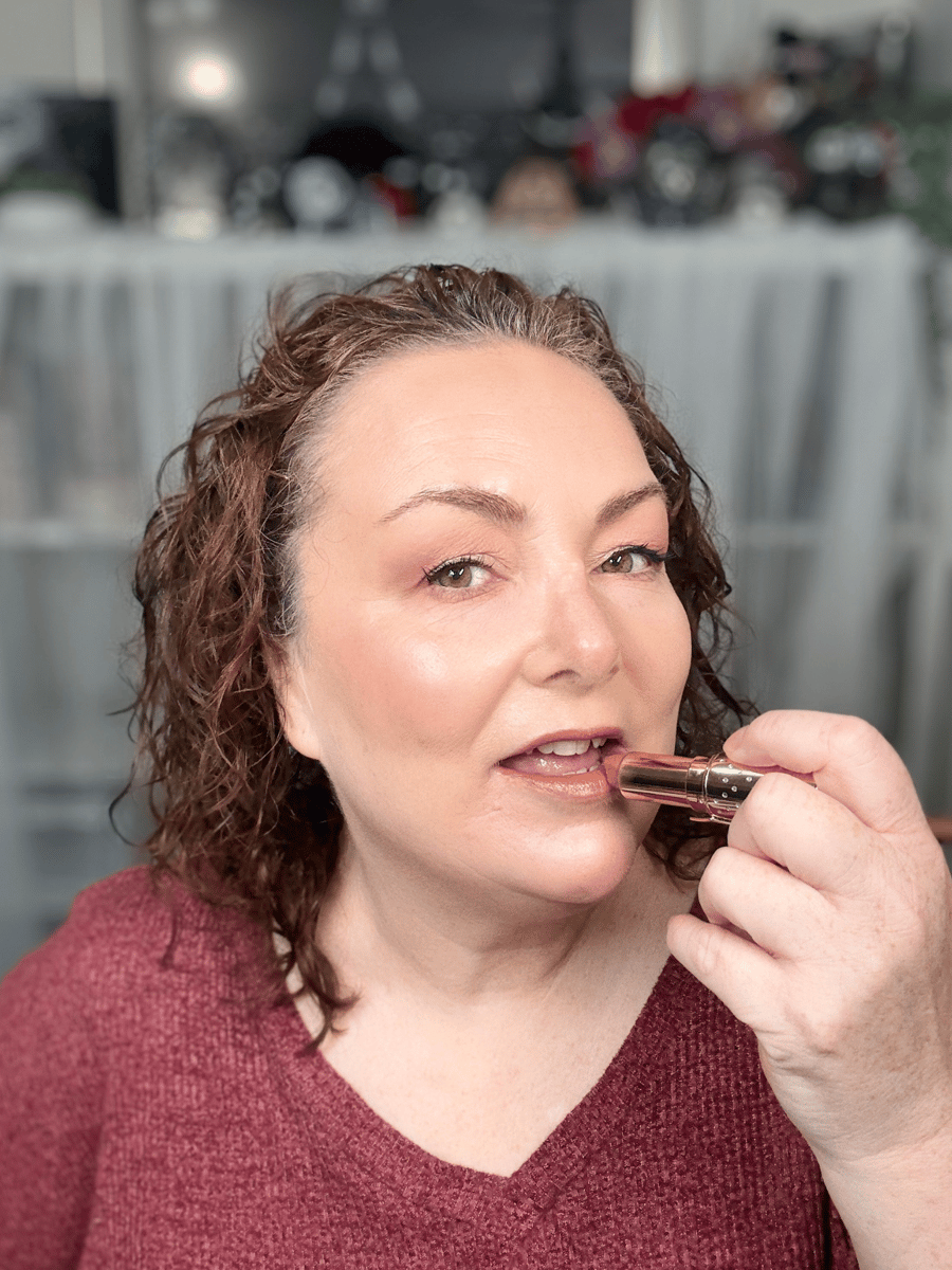 Teresa applying the Charlotte Tilbury K.I.S.S.I.N.G. lipstick in a nude shade.