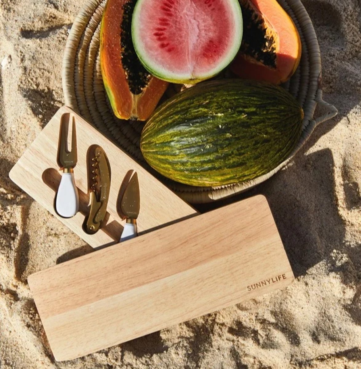 A Travel Cheese Board Set on the beach with fruit 