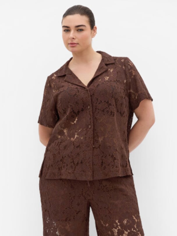 Model in brown lace shirt and pants.