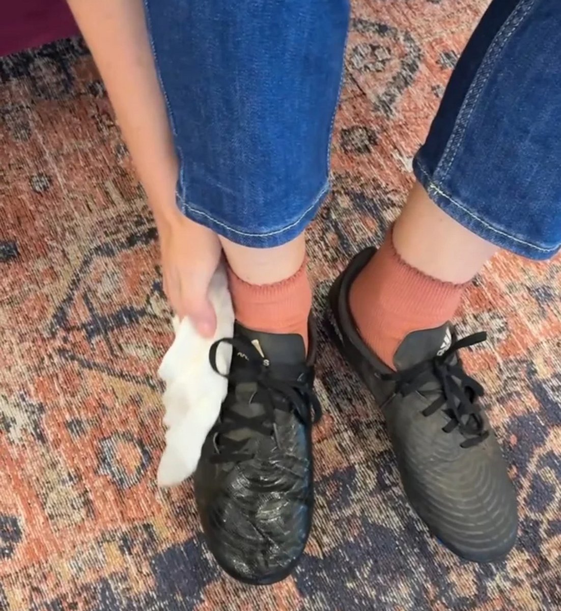 woman cleaning mud off shoes. 