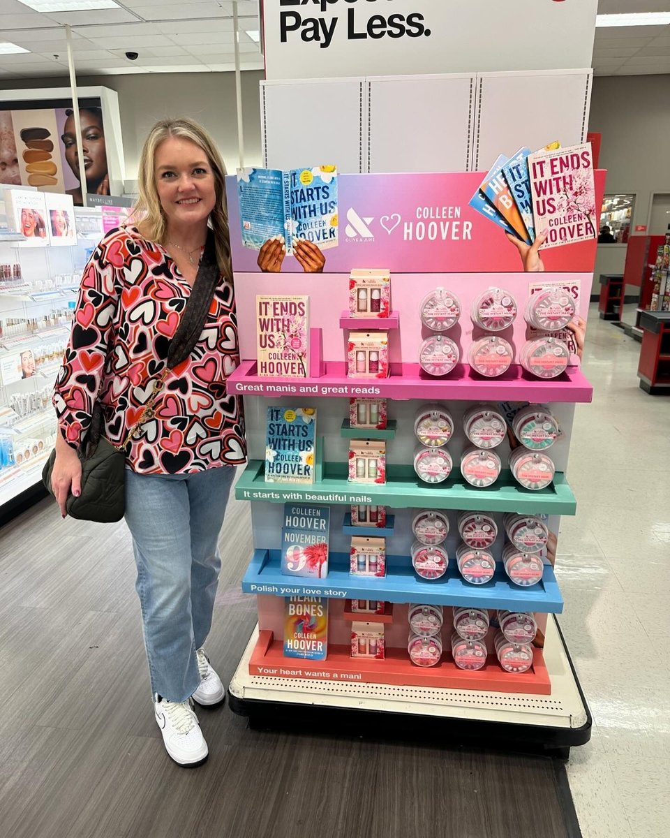 Colleen Hoover poses with a collection of her books in the supermarket.