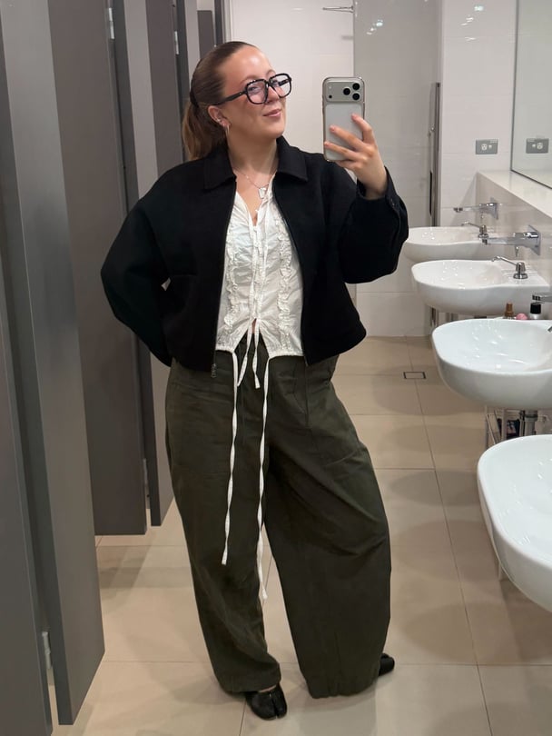 Mirror selfie of Lucy in utility pants.