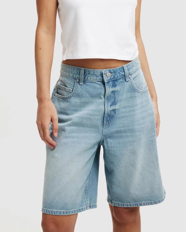 Cotton On denim Bermuda shorts or 'jorts', worn by female model with a white top.