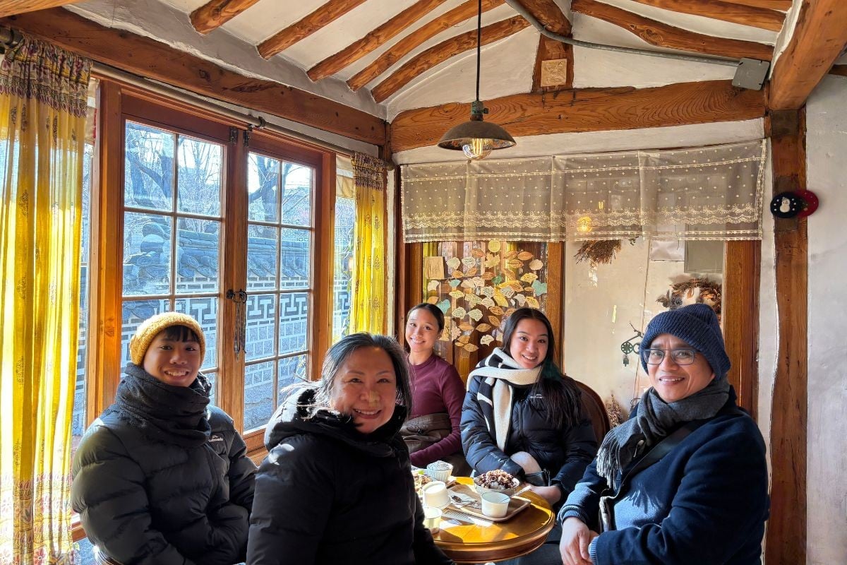 Five people sitting at a cafe.