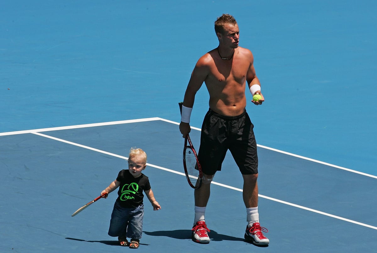 Lleyton Hewitt with his son Cruz Hewitt on the Australian Open tennis court.