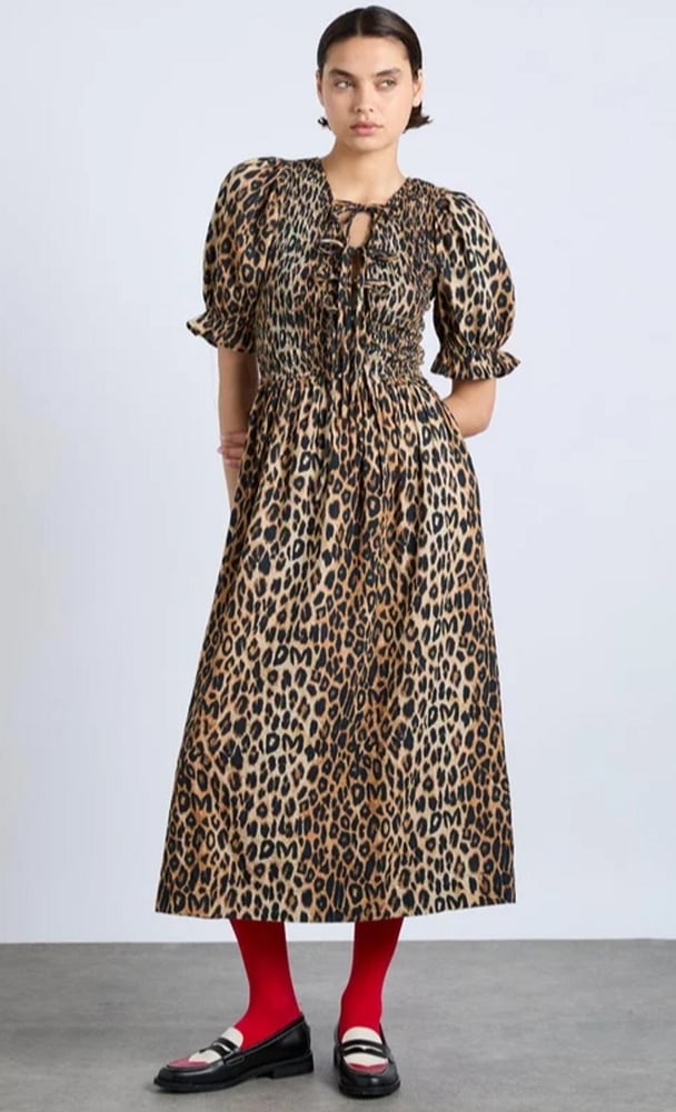 woman wearing a mid length dress with leopard spots and red stockings Damson Madder Bluebelle Midi Dress