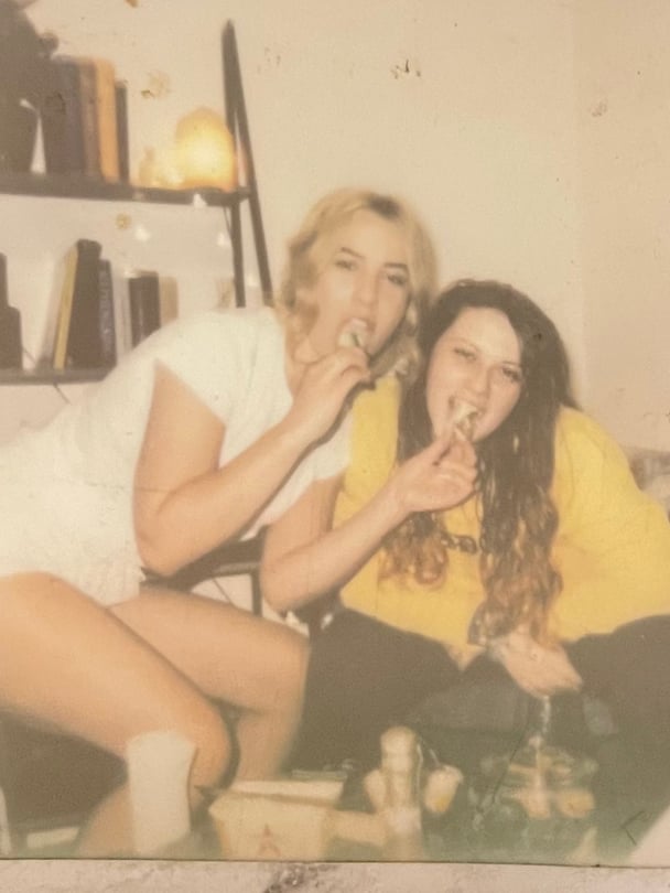 Old photo of Darcie and a friend eating snacks.