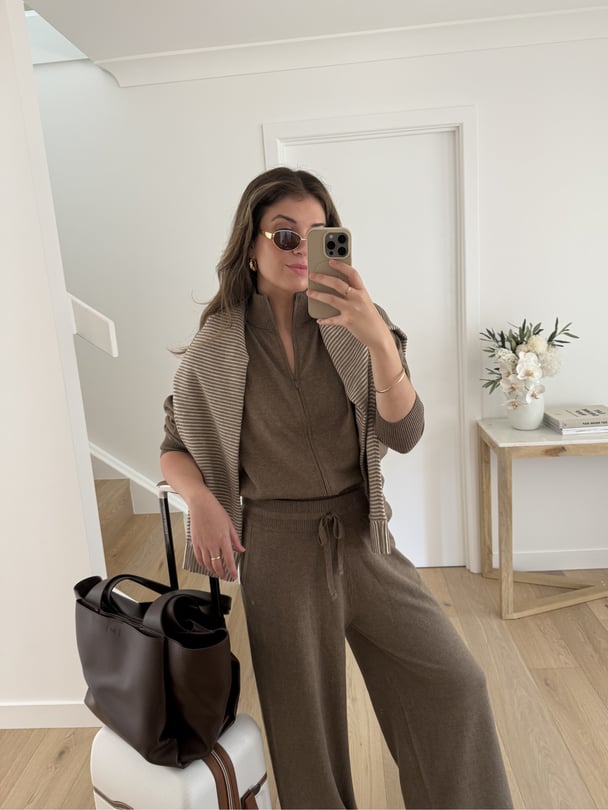 Paige in a brown tracksuit, wearing a comfy outfit for long-haul flight.