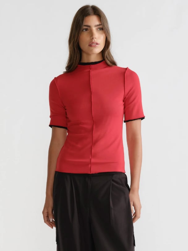Red knit high-neck t-shirt with black collar and sleeves.