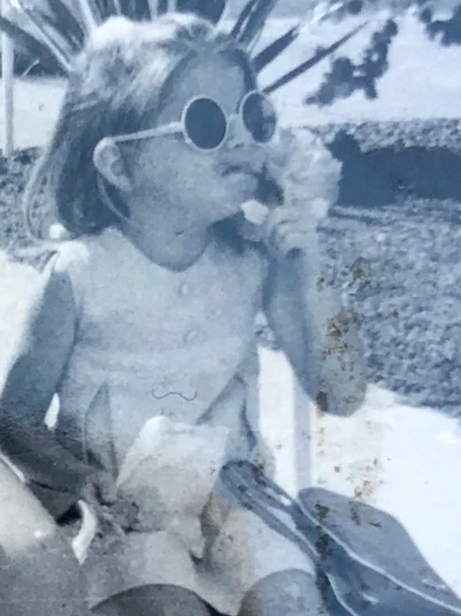 A black and white photo of Donna-Leigh Perfect wearing sunglasses as a child.